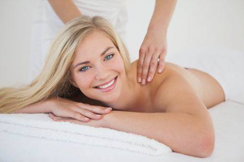 Pretty blonde enjoying a massage smiling at camera